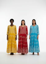 Three colourful dresses on hangers in a store setting