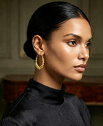 Model wearing 22K gold-plated beaded hoop earrings with graduated filigree beads, chand bali inspired design, luxury finish — Famaza Couture premium Pakistani jewellry.