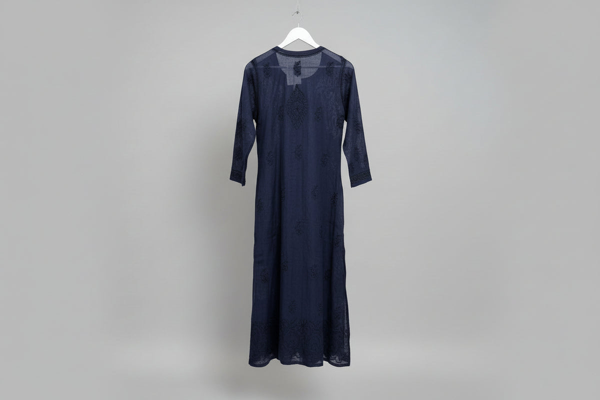 Navy blue dress on a mannequin against a decorative background with jewelry