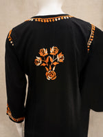 Black cotton kurta with orange and beige floral embroidery on the back and decorative trim along the neckline and sleeve cuffs, displayed on a mannequin.