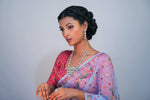 model is wearing hand embroidered saree and posing the ad necklace and earrings in this image