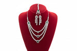 A AD triple layer cubic zirconia and emerald green centre stones necklace, earrings and maang tikka.