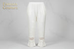 A Close-up of white embroidered cotton pants with pockets, showing the texture and design details. 