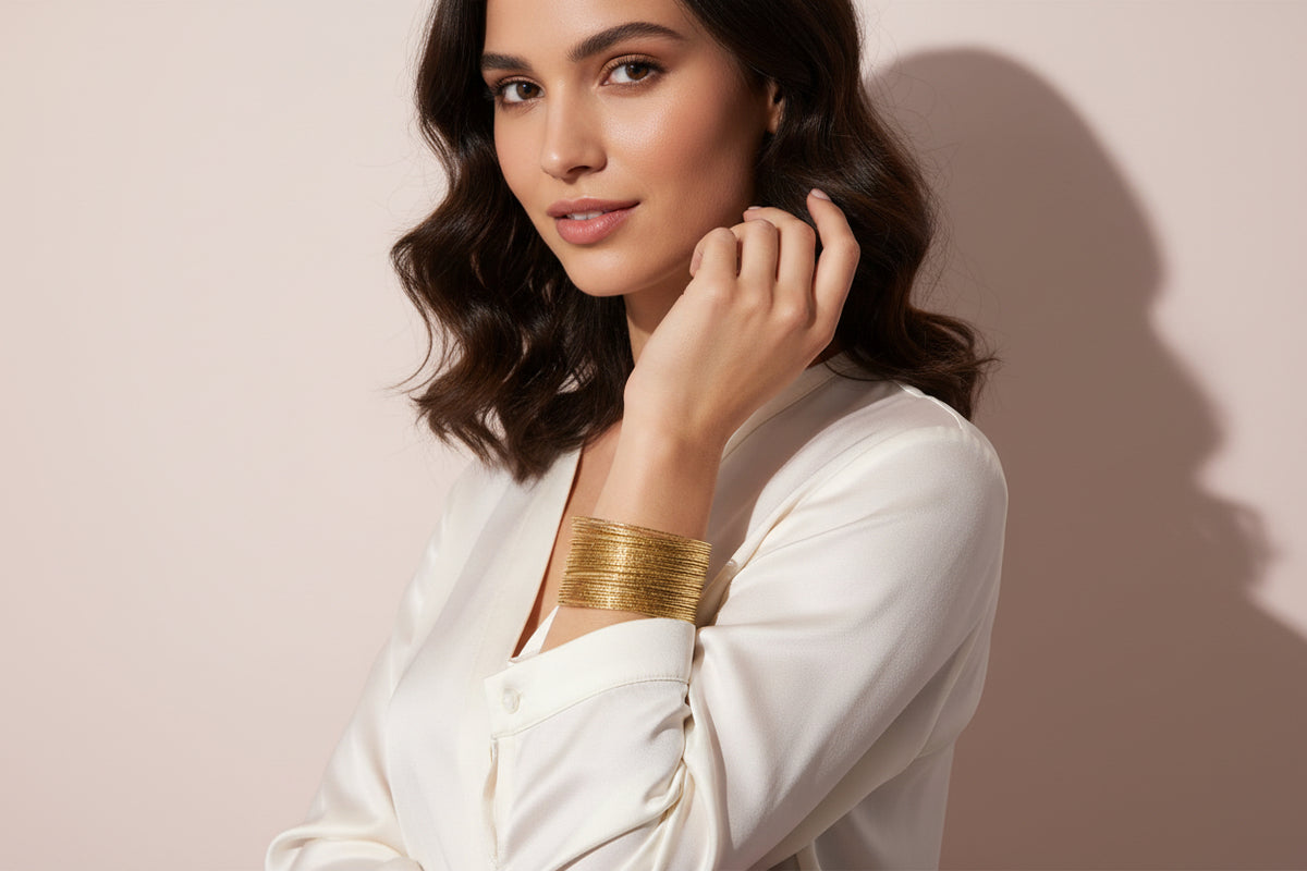 Gold bracelet on a light pink background