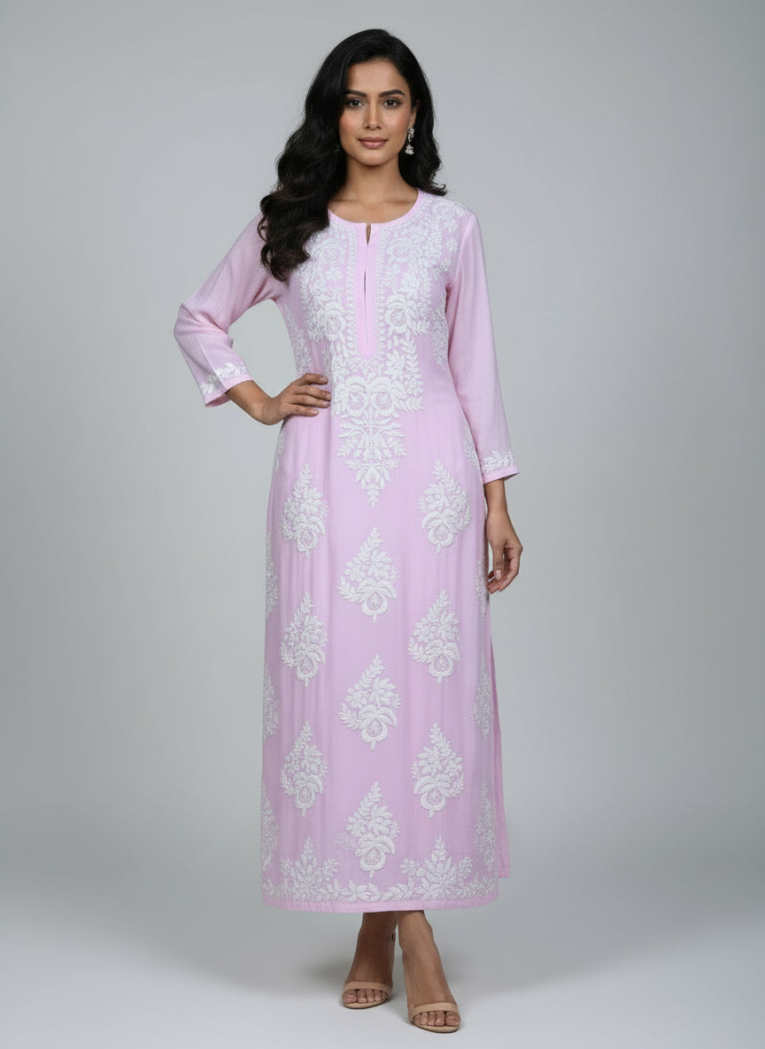 A baby pink colour Chikankari Kurti with white floral embroidery hanging on a hanger against a white background.
