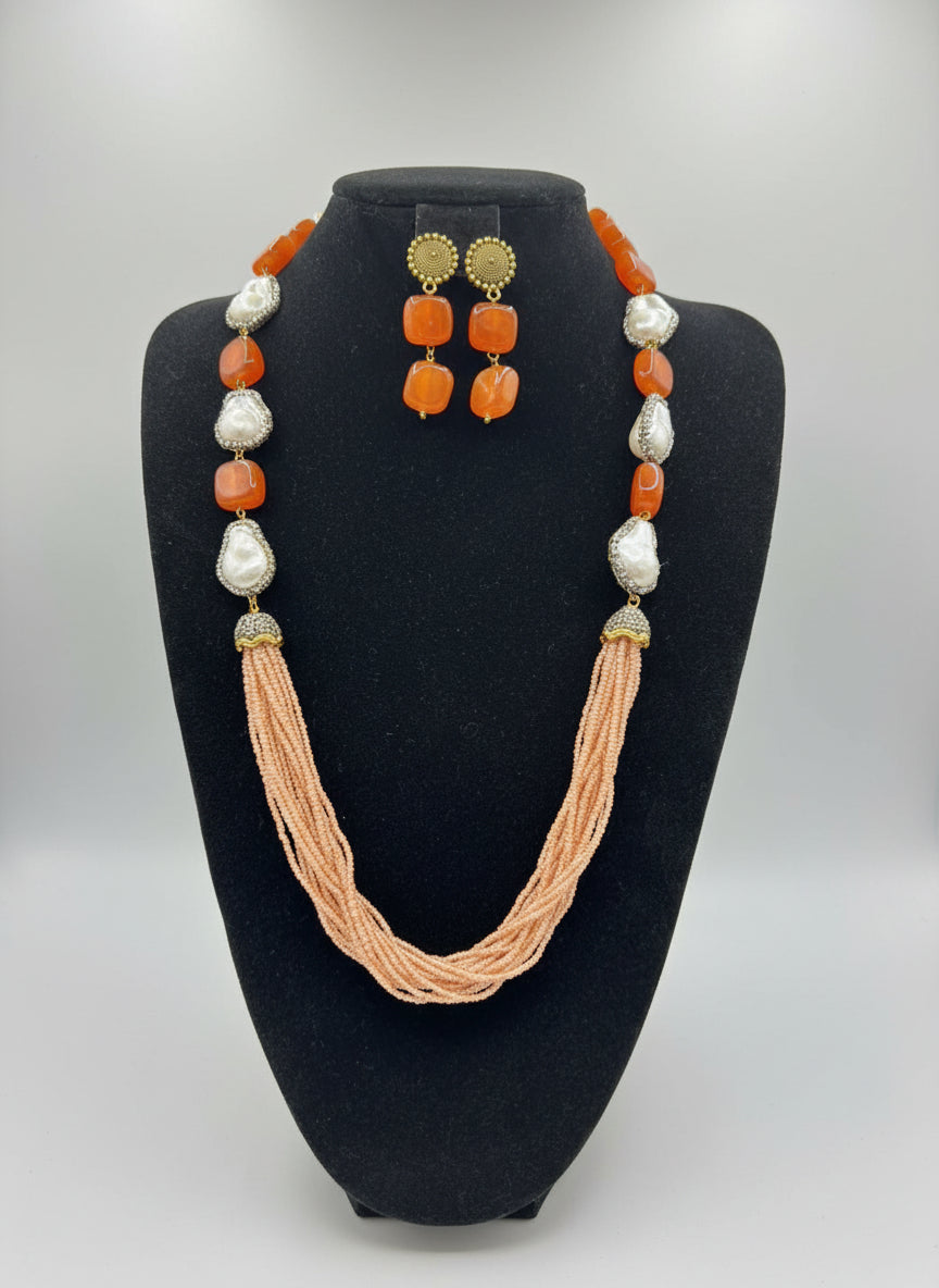 A black mannequin showcasing a Bollywood style Mona Lisa rust colour stone and peach colour nano crystal beaded Mala set, with white colours of beads and gold-tone accents.