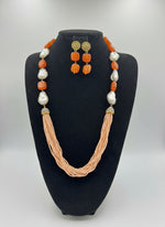 A black mannequin showcasing a Bollywood style Mona Lisa rust colour stone and peach colour nano crystal beaded Mala set, with white colours of beads and gold-tone accents.