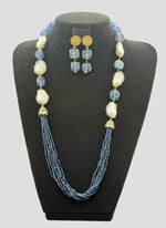 A black mannequin showcasing a Bollywood style Navy blue colour Mona Lisa stone and Navyblue colour nano crystal beaded Mala set, with white colours of baroque pearls and gold-tone accents. Party wear jewellery set. 