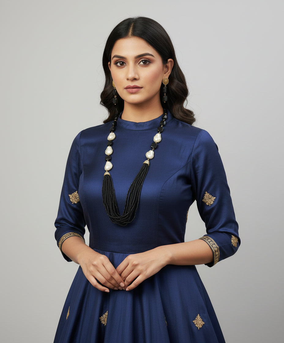 A black mannequin showcasing a Bollywood style black colour Mona Lisa stone and black colour nano crystal beaded Mala set, with white colours of baroque pearls and gold-tone accents. 