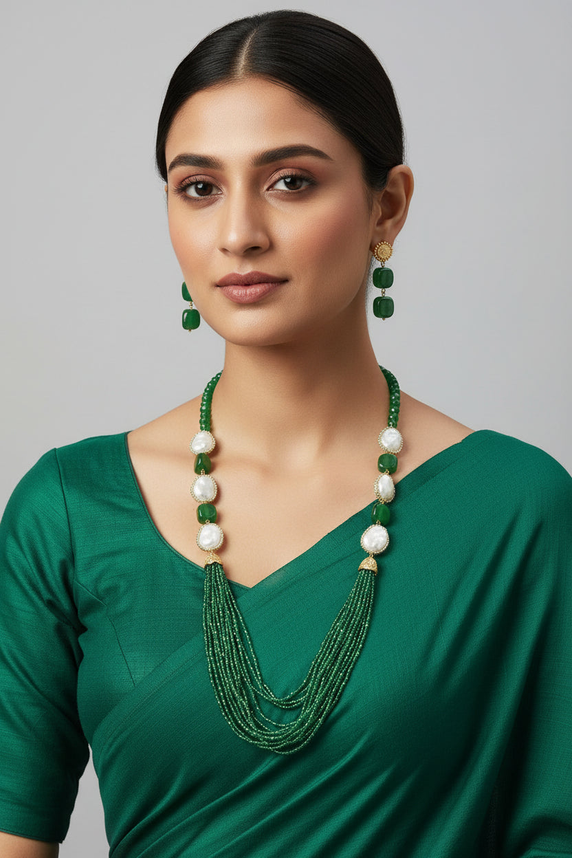 A black mannequin showcasing a Bollywood style bottle green Mona Lisa stone and bottle green nano crystal beaded Mala set, with white baroque beads and gold-tone accents.