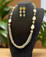 A black mannequin showcasing a Bollywood style grey colour Mona Lisa stone and grey colour nano crystal beaded Mala set, withgrey colour mona lisa stone and gold-tone accents. 