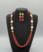 A black mannequin showcasing a Bollywood style maroon Mona Lisa stone and maroon nano crystal beaded Mala set, with white baroque beads and gold-tone accents.