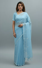 A blue cotton saree with floral embroidery and a blouse piece, draped over on a dummy by famaza couture 