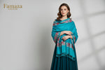 A blue pashmina scarf with detailed floral embroidery and tassels on the ends.