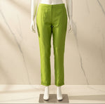 A bright lime green chanderi silk fabric straight trousers are hanging on a hanger for Famaza Couture website. 