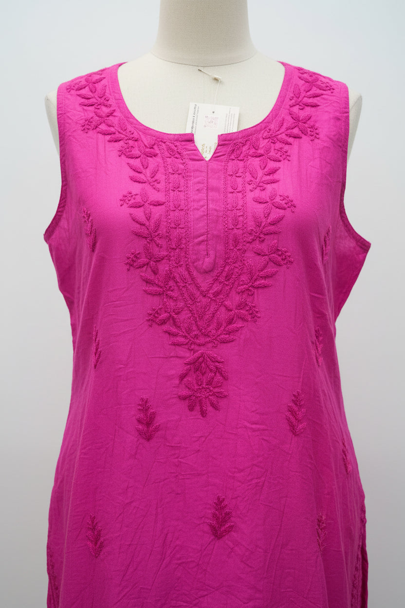 A bright magenta pink sleeveless kurta with floral embroidery on the chest and scattered embroidered motifs across the fabric, hanging on a white hanger.
