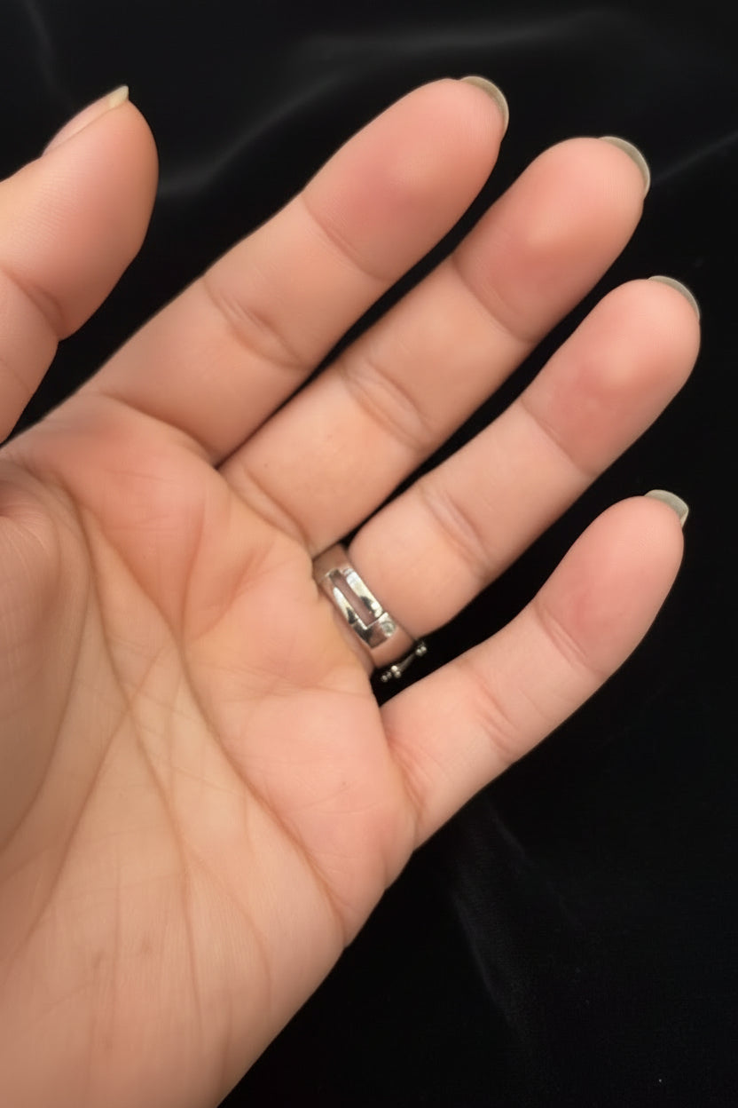A close-up of a hand wearing the rear view of adjustable finger silver ring in focus