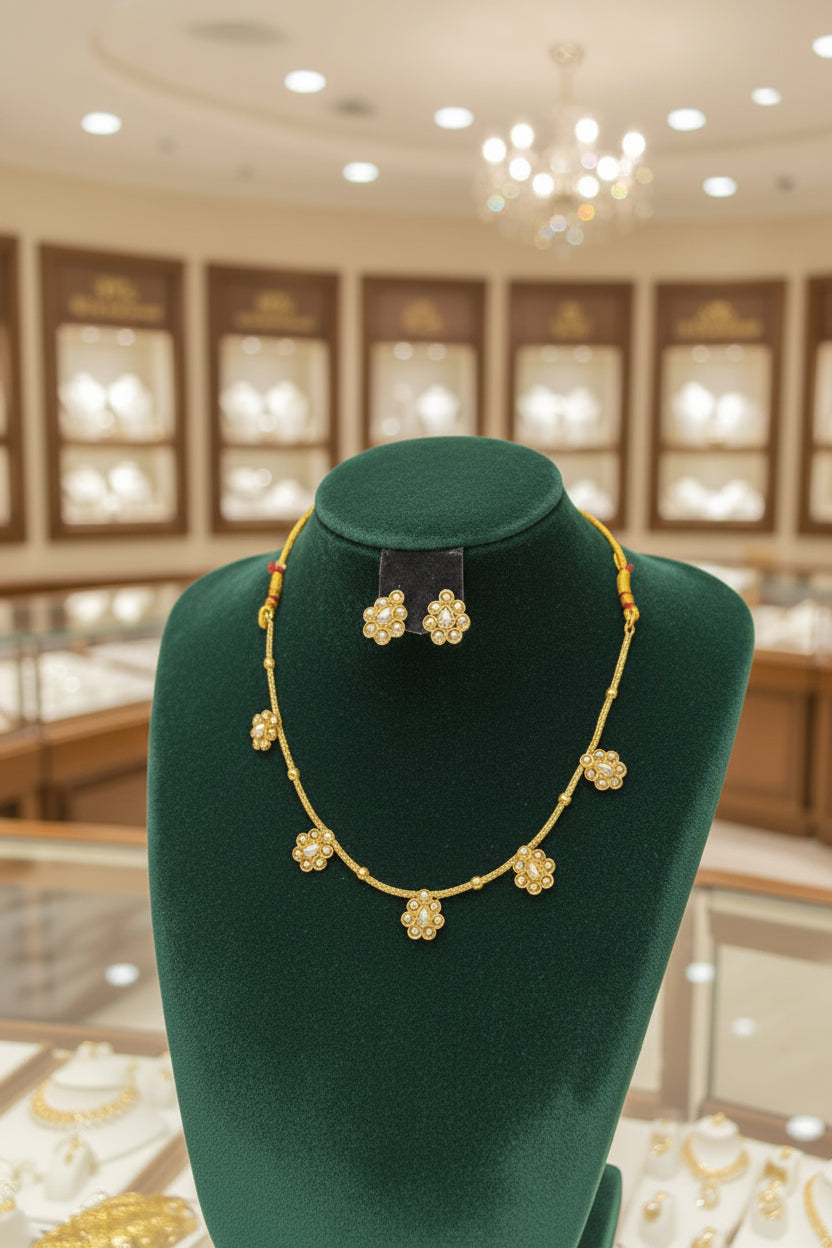  A delicate gold-toned jewelry set showcasing the spacing of the pearl floral charms and the coordinating uniquely shaped studs.