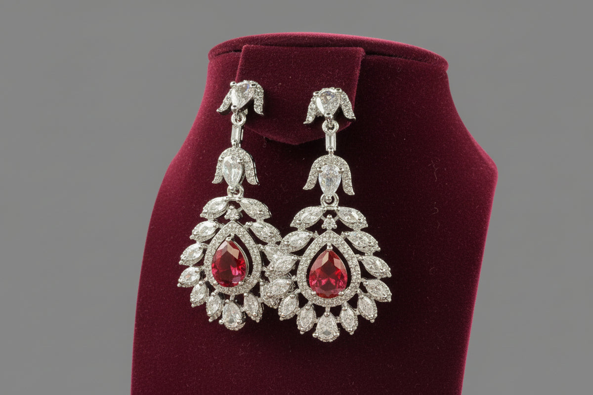  A earrings stand with leaf designs, featuring American diamonds and hot pink semi-precious stones. Party wear earrings. 