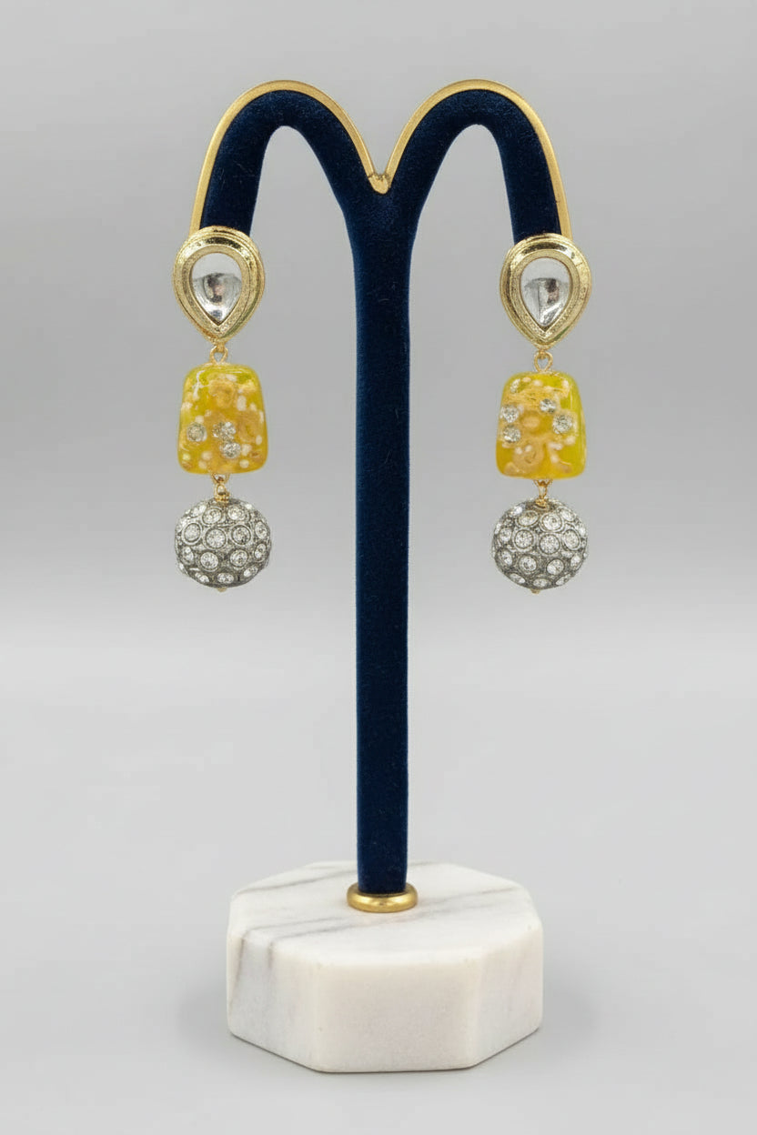 A gold-plated Kundan-studded and pearl-beaded handcrafted earrings, displayed against a black background. Party wear set. 