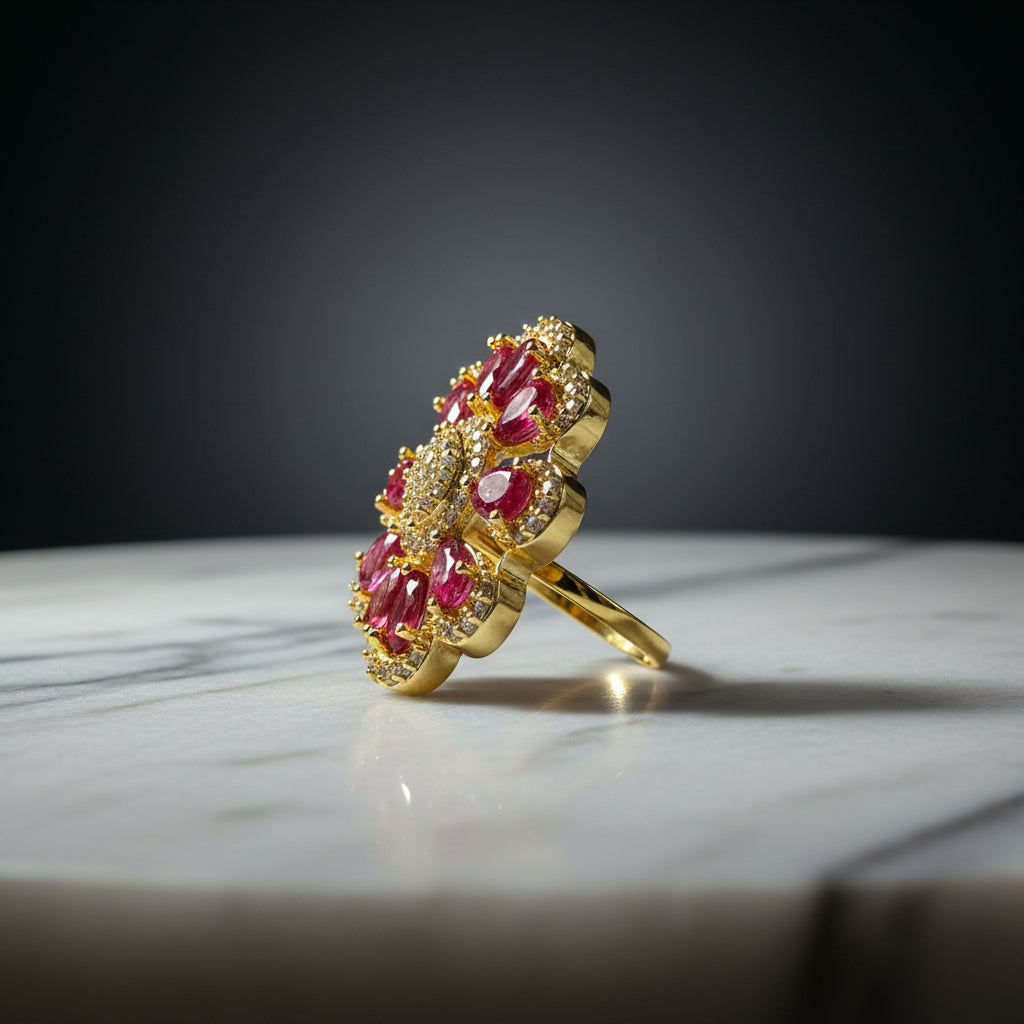A gold ring with multiple red gemstones, photographed on a textured white faux fur surface.