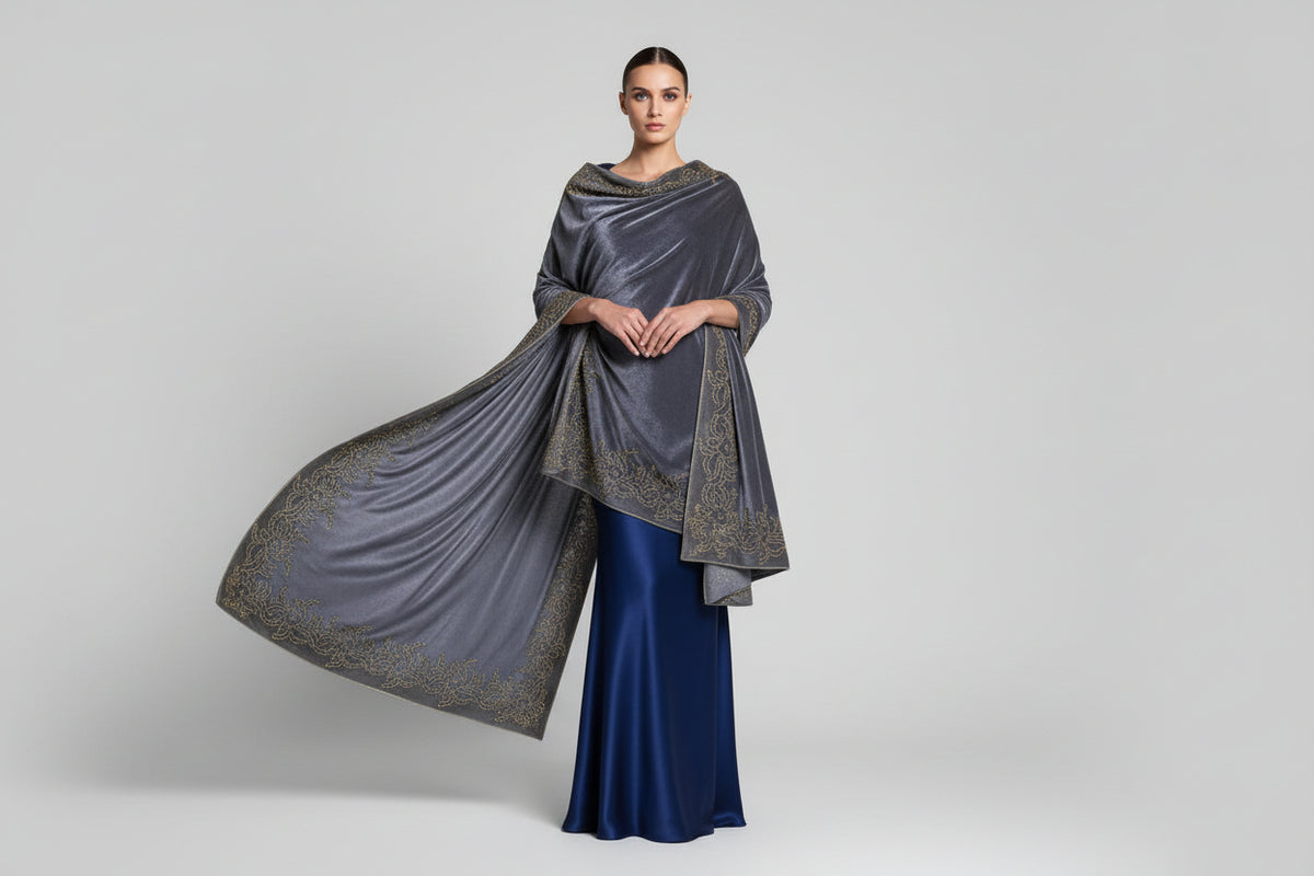 A grey colour velvet fabric shawl with gold colour nano beads embellishments and intricate floral patterns.