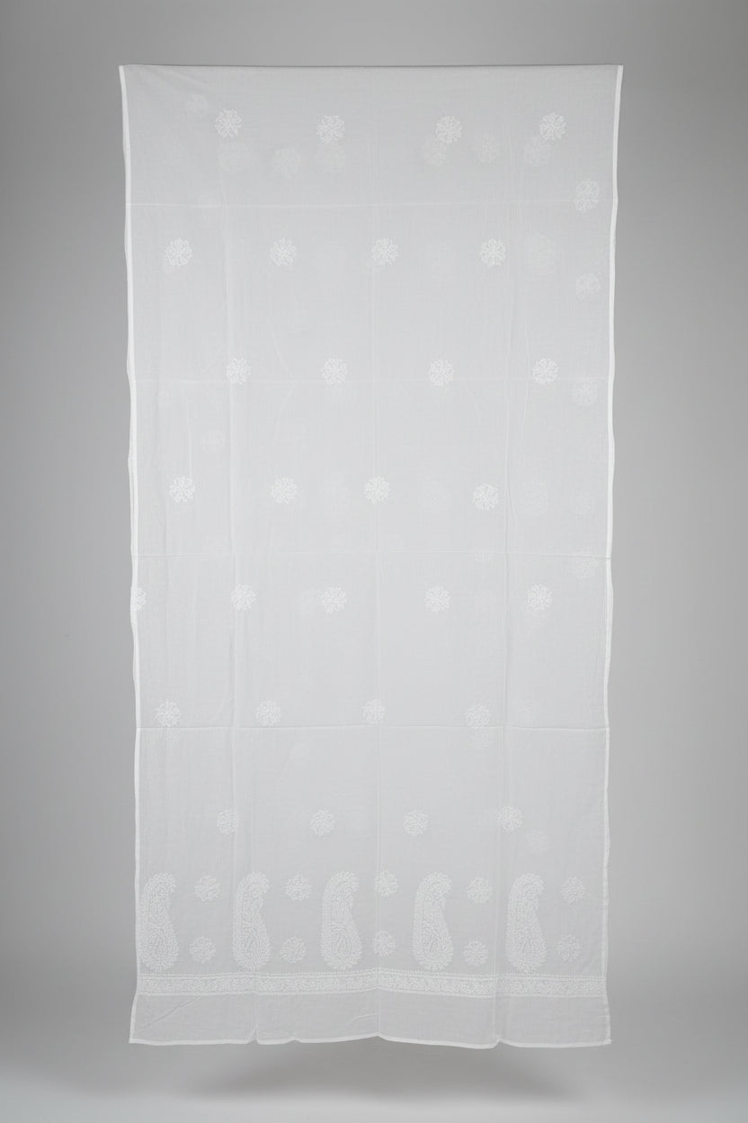 A large white sheer fabric panel or curtain with subtle tonal floral embroidery, hanging in a room with a window and mannequin visible in the background.