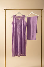 A lavender purple sleeveless tunic top with a matching straight trousers, displayed on a clothing rack in a Famaza Couture. 