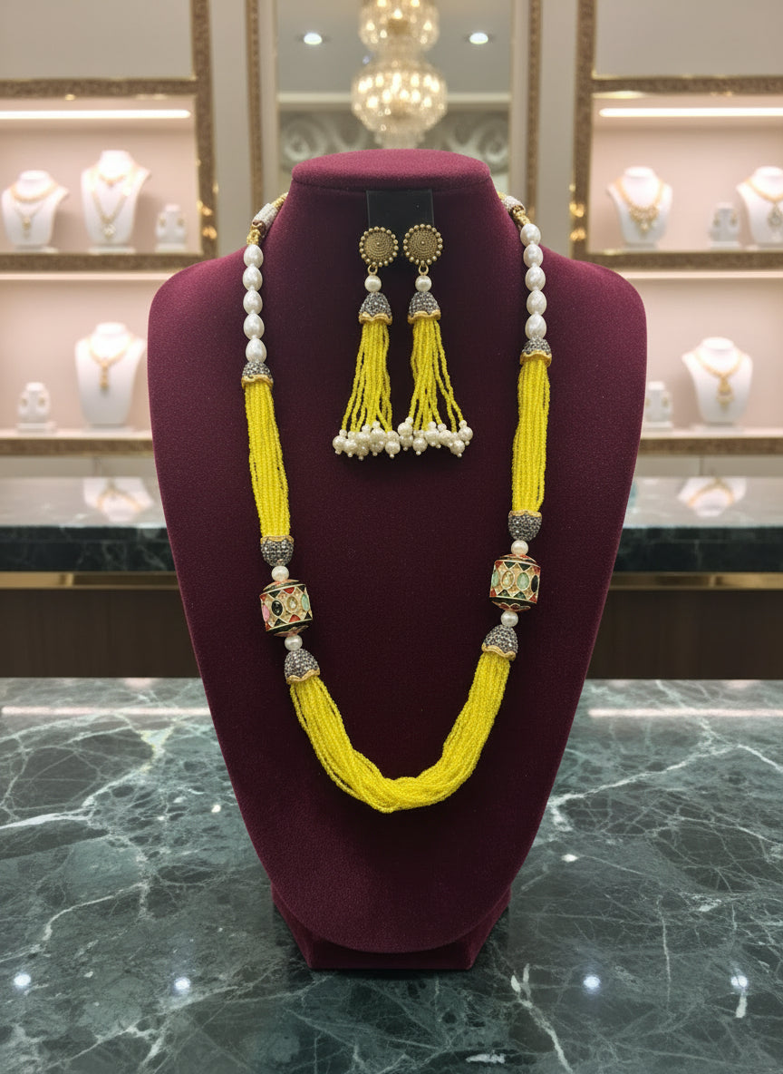 A luxurious Tanjore Art Meenakari beaded Mala Set featuring a bridal pearl necklace with accompanying earrings, predominantly in gold and white colours with ornate designs.