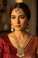 A luxurious rose gold polished bridal jewellery set featuring a wide necklace and matching drop earrings with hanging teardrop pearls.