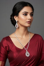 A mannequin showcasing a necklace and earrings set with leaf designs, featuring American diamonds and hot pink semi-precious stones.