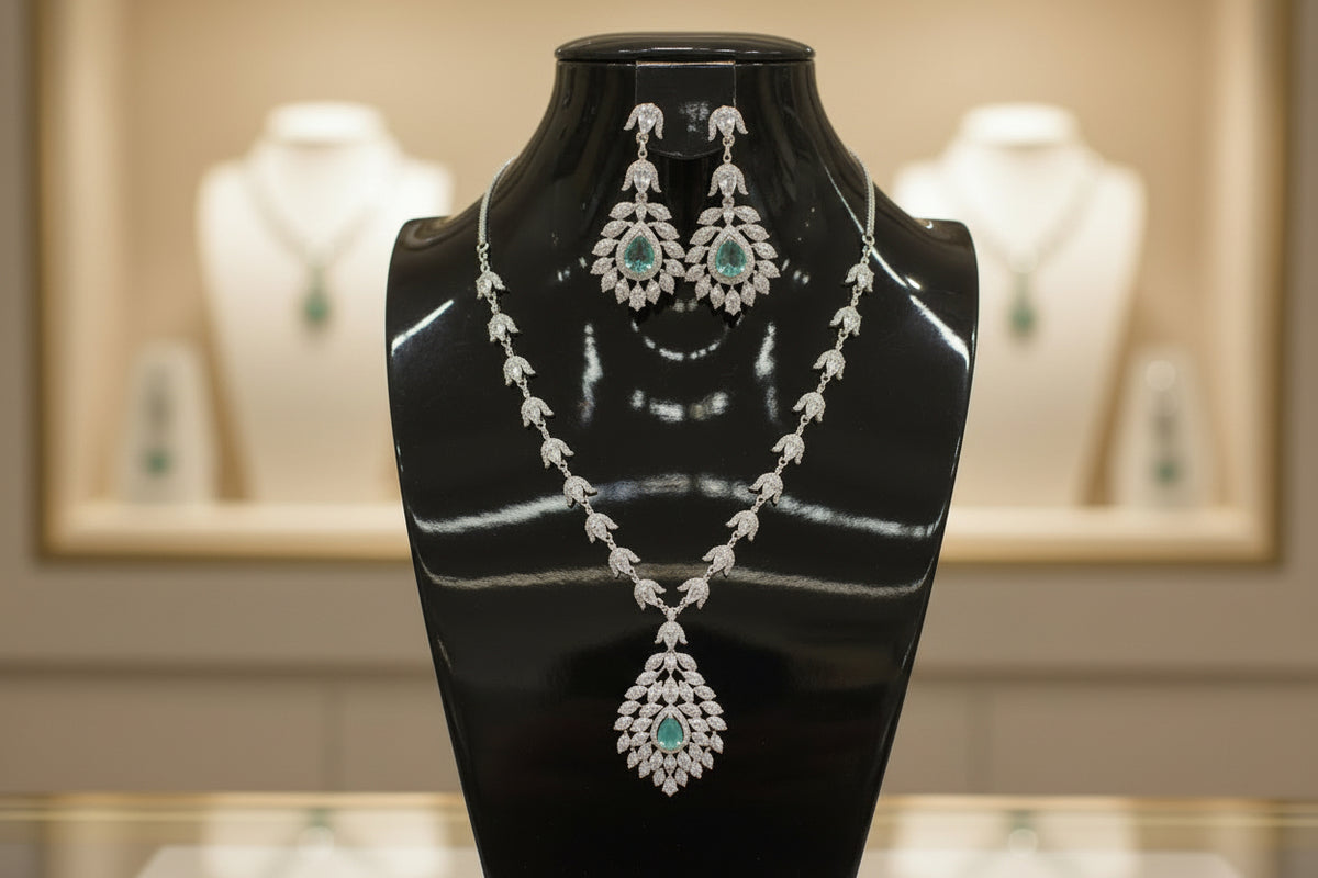 A mannequin showcasing a necklace and earrings set with leaf designs, featuring American diamonds and turquoise semi-precious stones.