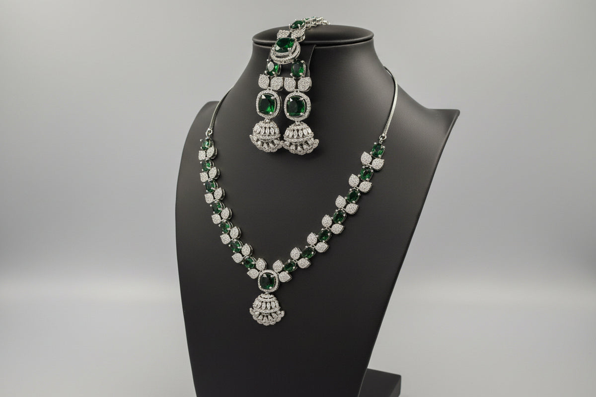 A mannequin showcasing a necklace set with bottle green and white stones, accompanied by earrings and a maang tikka. 