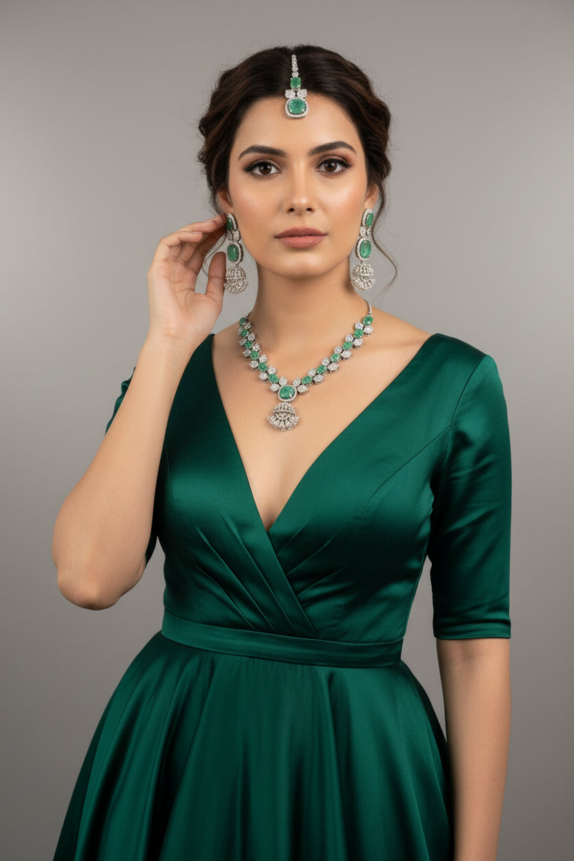 A mannequin showcasing a necklace set with green and white stones, accompanied by earrings and a maang tikka. Party wear set. 