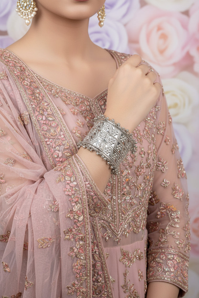 A model elegantly styled in a floral embossed silver-finish brass cuff; a statement piece of posh jewellery perfect for pairing with luxury evening wear or bridal ensembles.