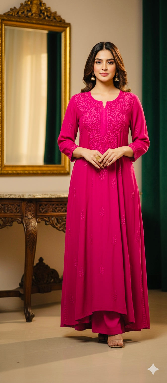 Woman in a pink traditional outfit standing in a room with a mirror and decorative items.