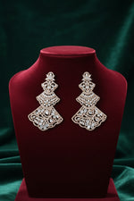 A pair of Rose gold-tone three-tiered chandelier earrings with intricate filigree lattice metalwork and sparkling cubic zirconia crystals, displayed on a red velvet jewellery bust.