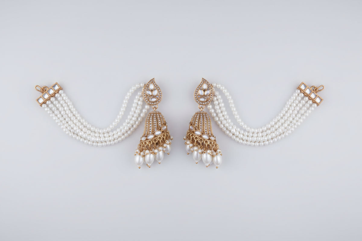 A pair of a woman wearing a white beaded earring with rose gold accents jhumkey.