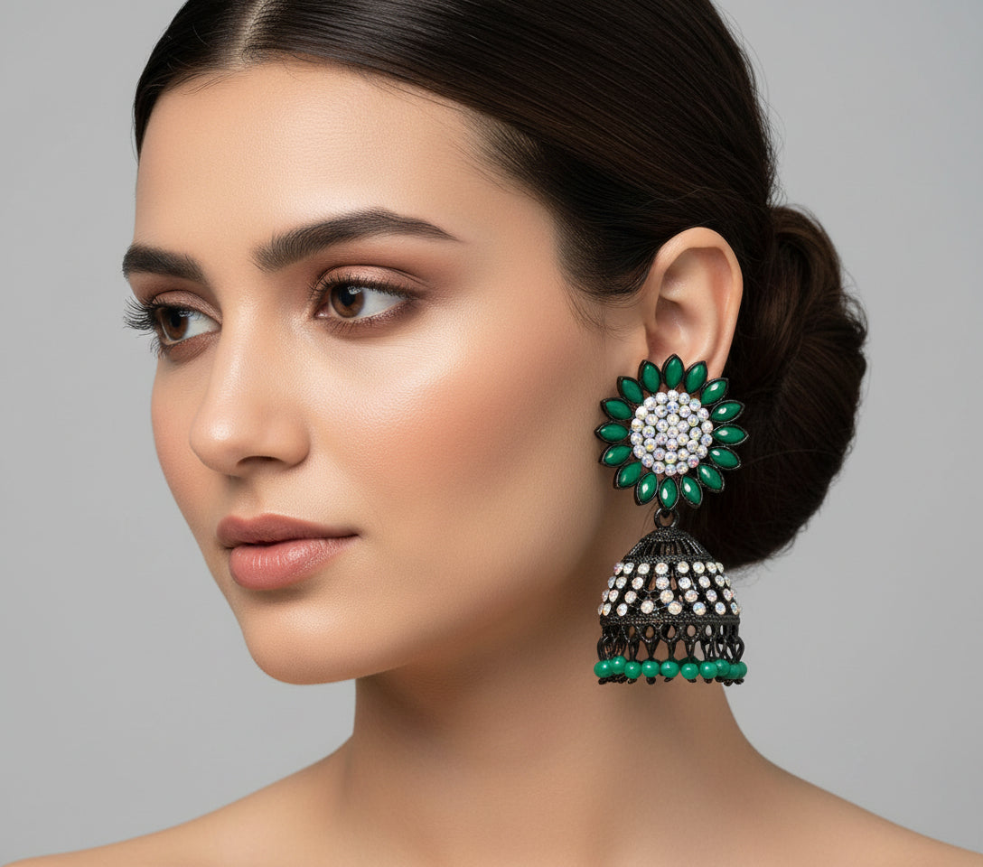 A pair of black base metal Jhumki earrings with sunflower designs, featuring bottle green and silver multi shade stones and sky blue nano hangings.