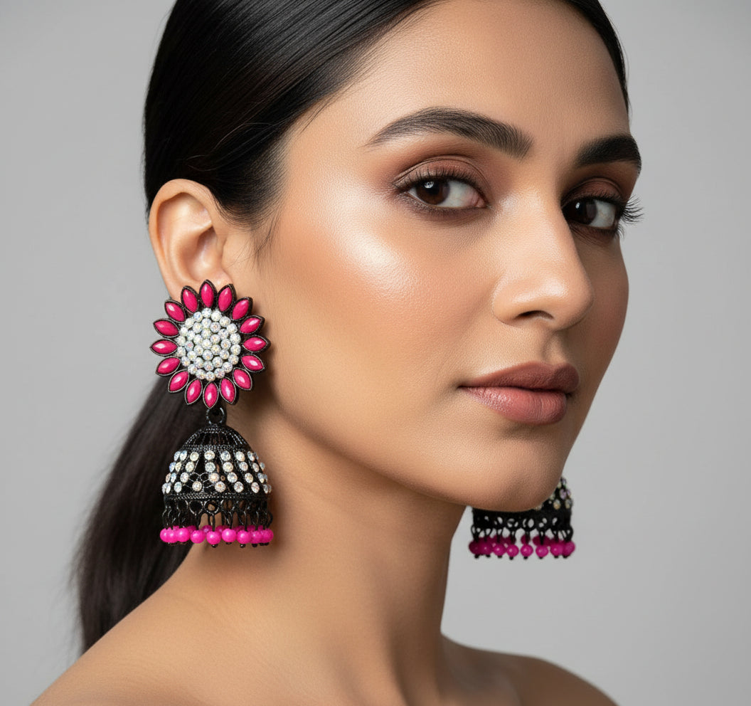 A pair of black base metal Jhumki earrings with sunflower designs, featuring hot pink and silver multi shade stones and sky blue nano hangings.