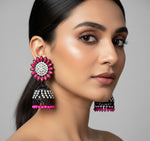 A pair of black base metal Jhumki earrings with sunflower designs, featuring hot pink and silver multi shade stones and sky blue nano hangings.