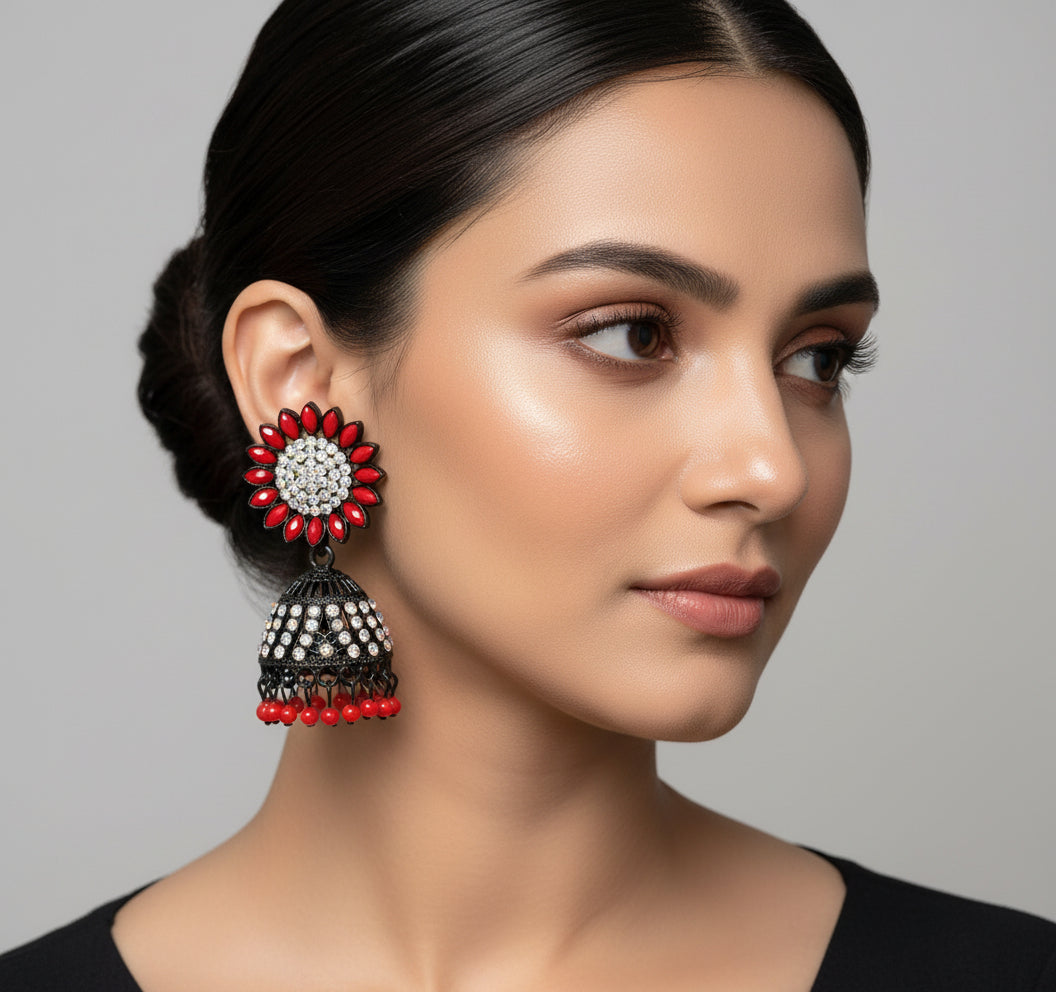 A pair of black base metal Jhumki earrings with sunflower designs, featuring red and silver multi shade stones and sky blue nano hangings.