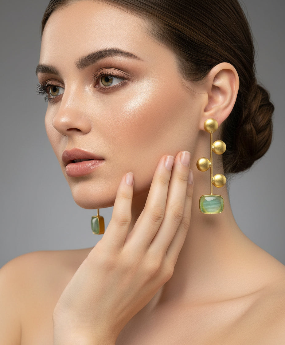 A pair of gold-plated earrings with turquoise Monalisa stone and coin details.