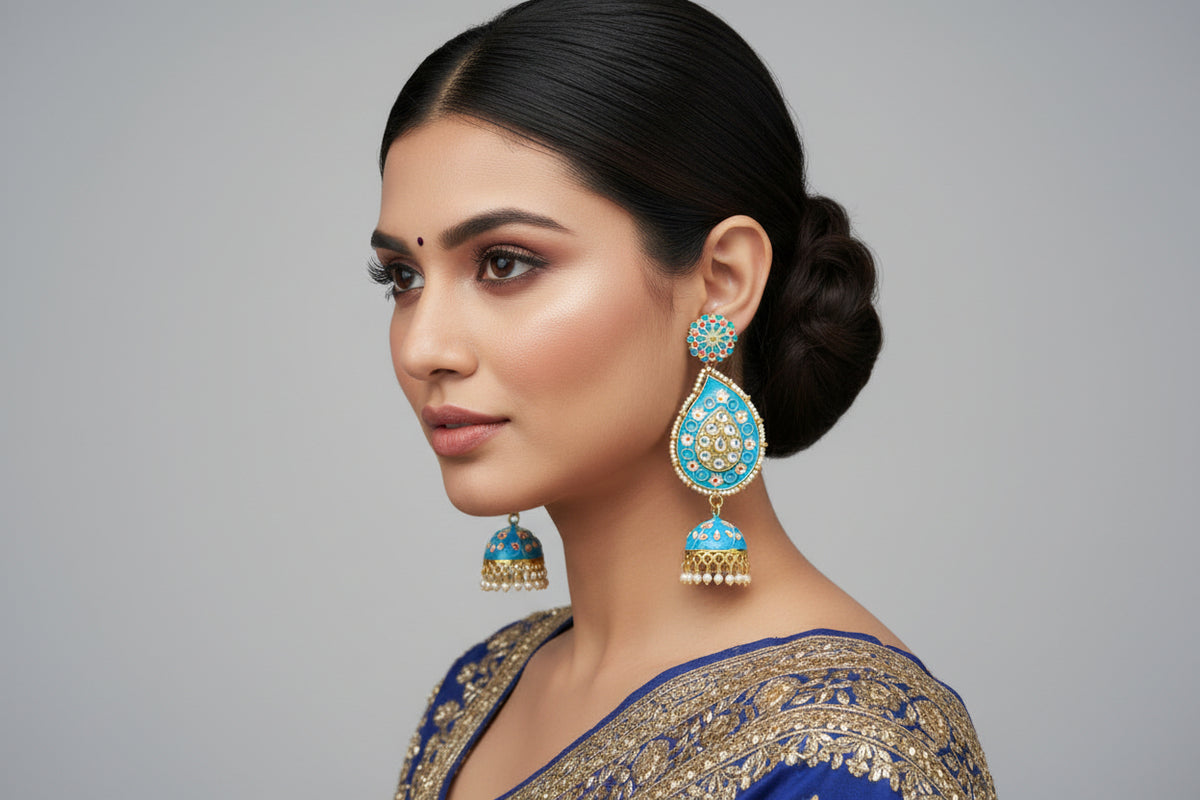 A pair of gold-plated sky blue Meenakari long Jhumka earrings with sky blue enamel paint and nano pearl drops, displayed on a stand.