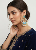 A pair of gold-toned chandbali earrings with blue meenakari and kundan studded details along with pearls.