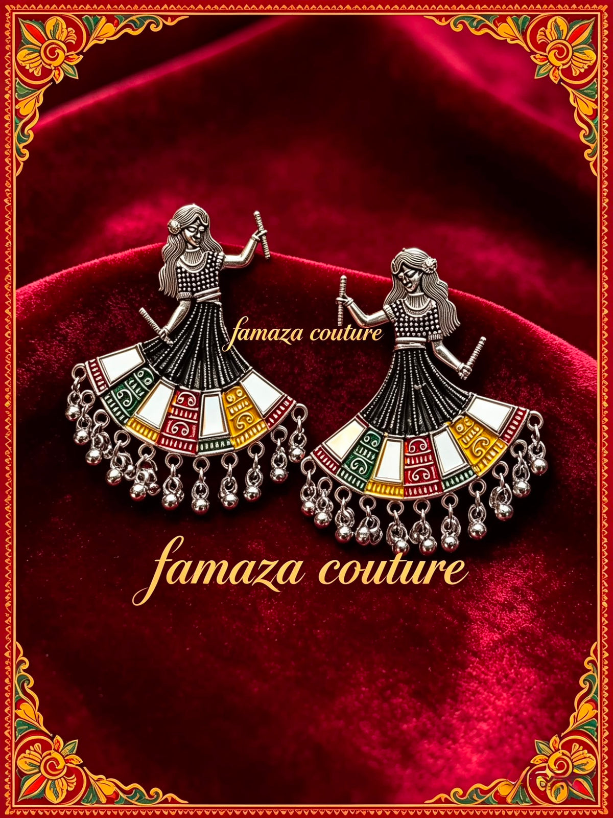 A pair of silver-toned earrings shaped like dancing women with colourful enamel details, displayed on a deep red velvet background with a decorative gold border and the text 'famaza couture'.