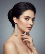 A pair of silver finish cubic zirconia drop earrings with red doublet semi precious stones.