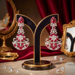 A pair of vibrant fuchsia chandelier earrings displayed on a black velvet stand, as shown in the product image.