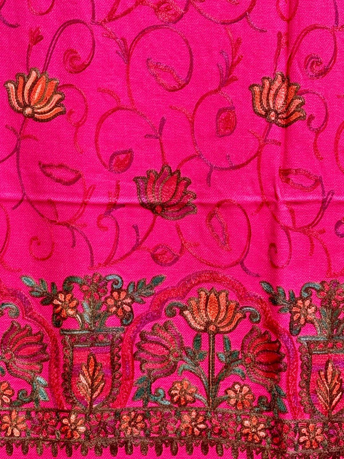 A pink Kashmiri embroidered pashmina scarf with a floral pattern and tassels along the edges.
