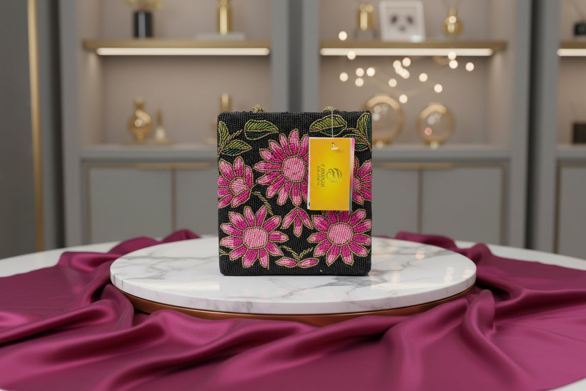 A pink floral handcrafted tote bag with glass bead embroidery on a dark base, displayed on a wooden surface.